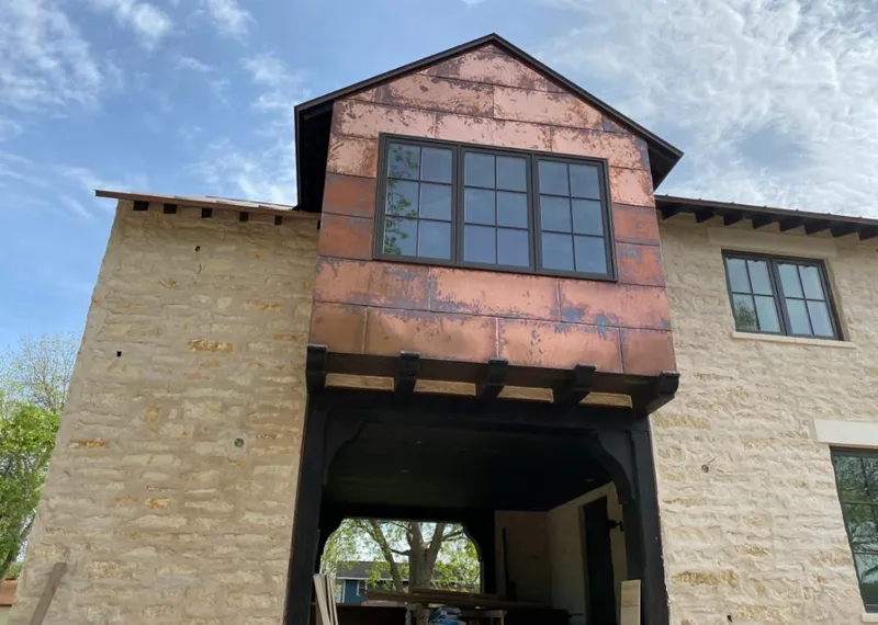 Copper metal panel facade on a stone building for Skylight Installation in Orange